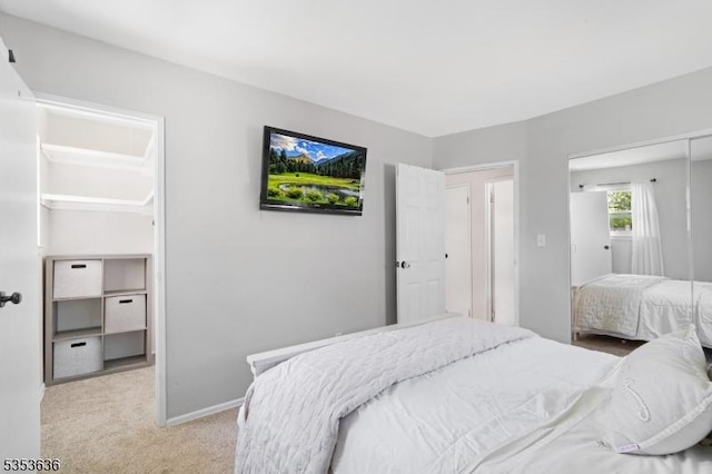 carpeted bedroom with baseboards and a closet