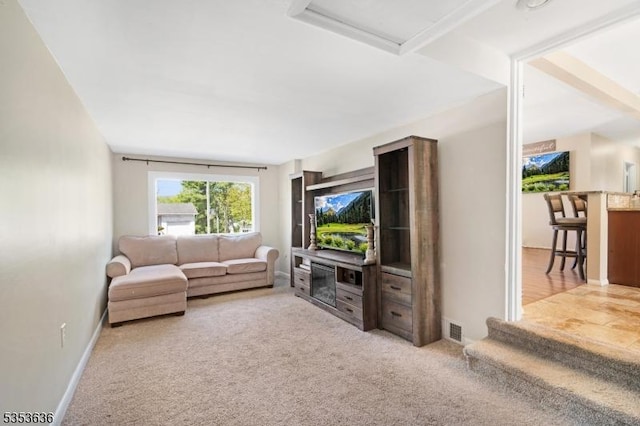 living area featuring attic access, baseboards, visible vents, and carpet