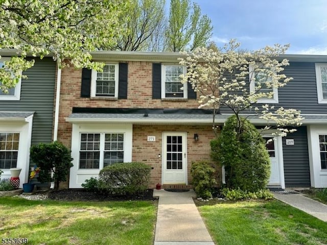 view of front facade featuring a front yard and brick siding