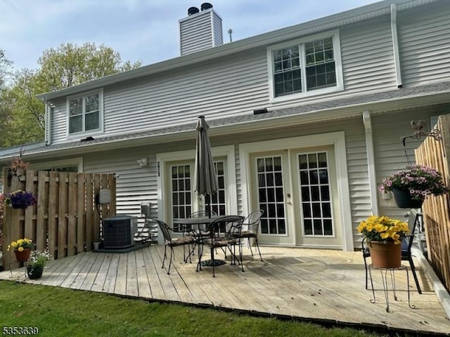 back of house with outdoor dining space, a chimney, french doors, and a wooden deck