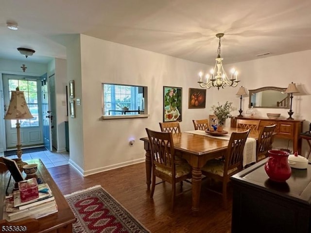dining area with a notable chandelier, wood finished floors, and baseboards