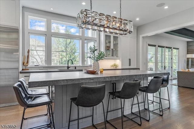 kitchen featuring a center island, a sink, stainless steel built in fridge, and white cabinets