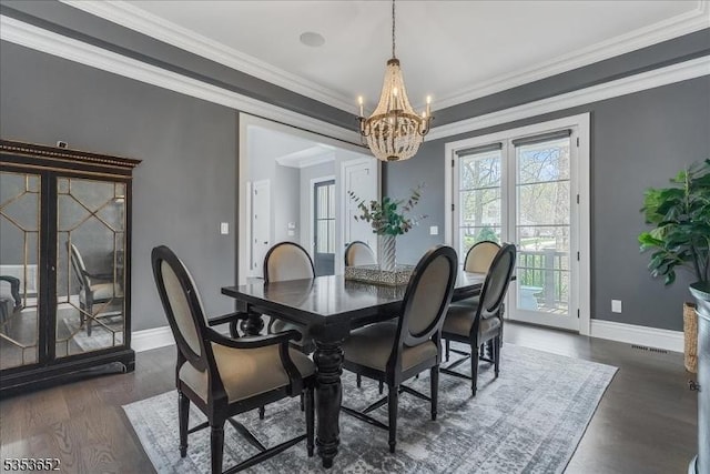 dining area featuring crown molding, an inviting chandelier, baseboards, dark wood-type flooring, and visible vents