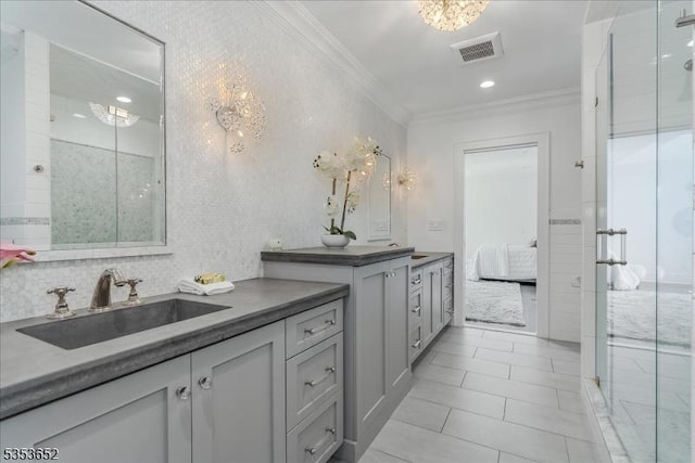bathroom featuring a sink, crown molding, a shower with shower door, and visible vents