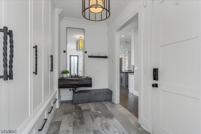 mudroom with light wood-type flooring and ornamental molding