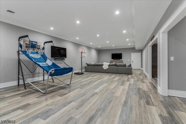living room with crown molding, baseboards, visible vents, and wood finished floors