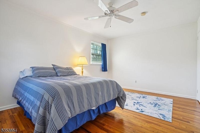bedroom featuring baseboards, ceiling fan, and wood finished floors