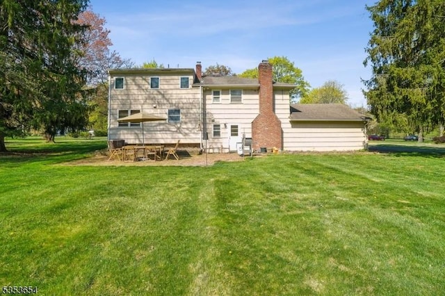 back of house with a lawn and a chimney
