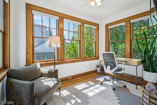 sunroom / solarium featuring baseboards and wood finished floors