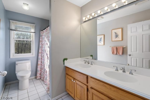 bathroom with a sink, tile patterned floors, toilet, and double vanity