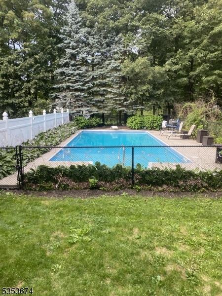 view of swimming pool with a fenced in pool, fence, and a yard