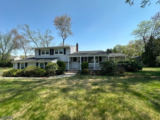 split level home featuring a chimney and a front lawn