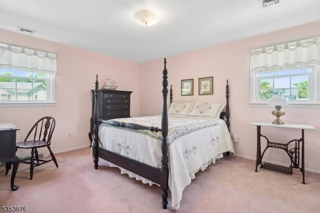 bedroom with multiple windows, light carpet, and visible vents