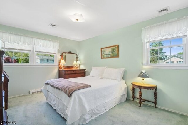 bedroom with baseboards, multiple windows, and carpet