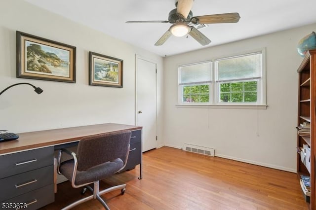 office space with a ceiling fan, baseboards, visible vents, and light wood-type flooring