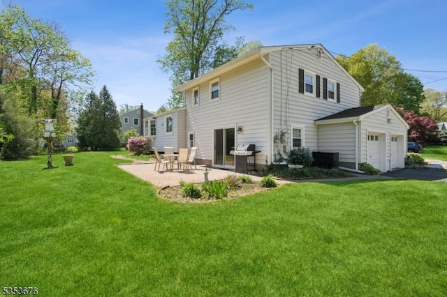 rear view of property with a lawn, a patio, an attached garage, and driveway