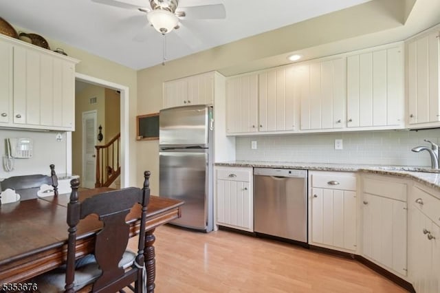 kitchen with a ceiling fan, a sink, appliances with stainless steel finishes, and backsplash