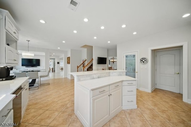 kitchen with a kitchen island, light tile patterned floors, a notable chandelier, and light countertops