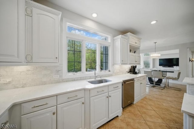 kitchen with white cabinets, a sink, dishwasher, backsplash, and pendant lighting