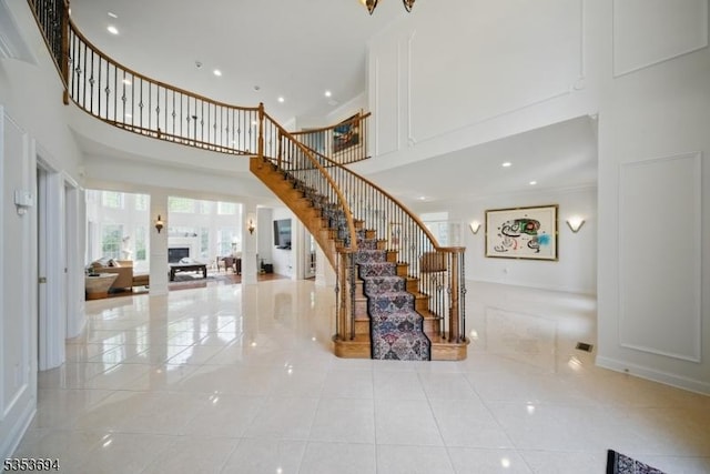 stairs featuring recessed lighting, a high ceiling, and tile patterned floors