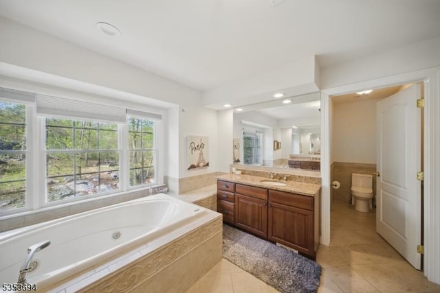 bathroom featuring toilet, tile patterned flooring, a bath, and vanity