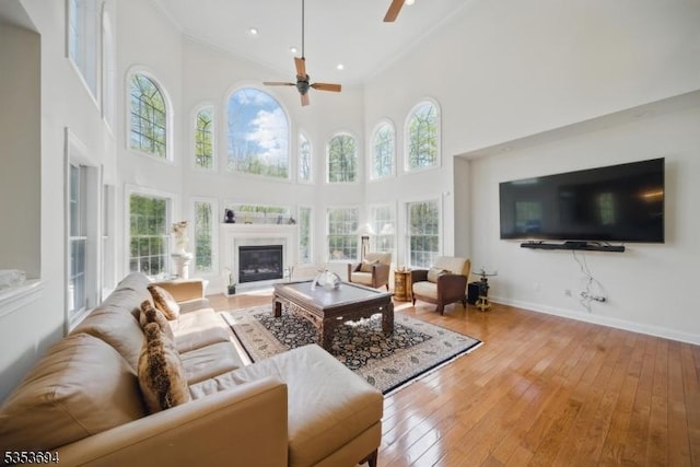 living room with a healthy amount of sunlight, ornamental molding, and a ceiling fan