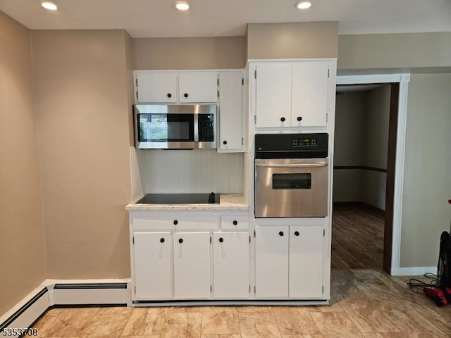 kitchen with white cabinets, appliances with stainless steel finishes, light countertops, recessed lighting, and a baseboard radiator