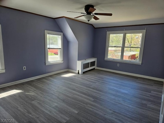 additional living space with baseboards, ceiling fan, and dark wood finished floors