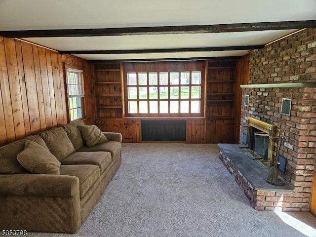 living area featuring a brick fireplace, carpet flooring, wood walls, and beam ceiling