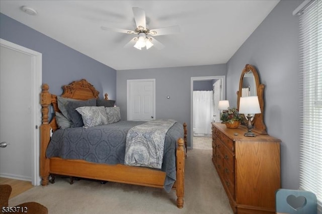 bedroom with light carpet and a ceiling fan