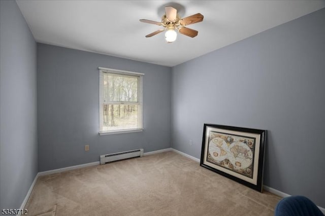spare room featuring a baseboard heating unit, carpet flooring, a ceiling fan, and baseboards