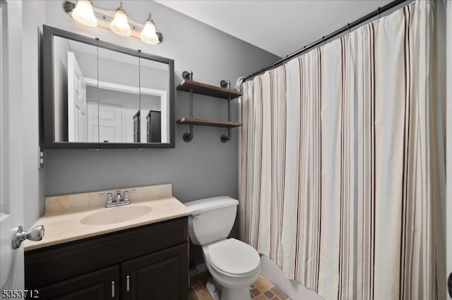 bathroom featuring toilet, vanity, and a shower with curtain