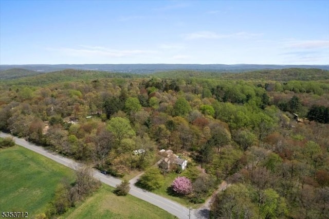 aerial view of property and surrounding area featuring a forest