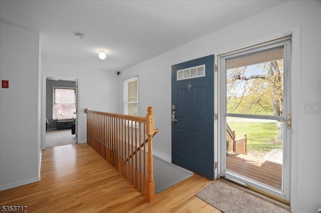 foyer entrance featuring light wood finished floors and baseboards