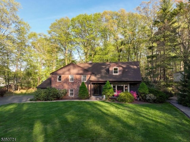 view of front facade with a front lawn and brick siding
