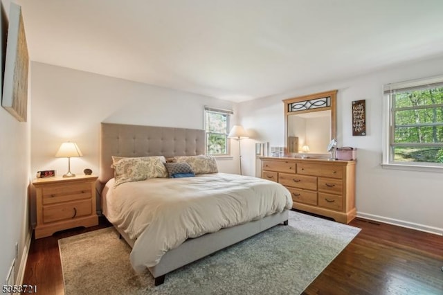 bedroom with baseboards and dark wood finished floors