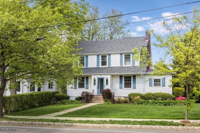 view of front of property featuring a chimney and a front yard