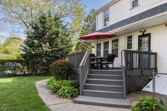 deck featuring a yard and stairs