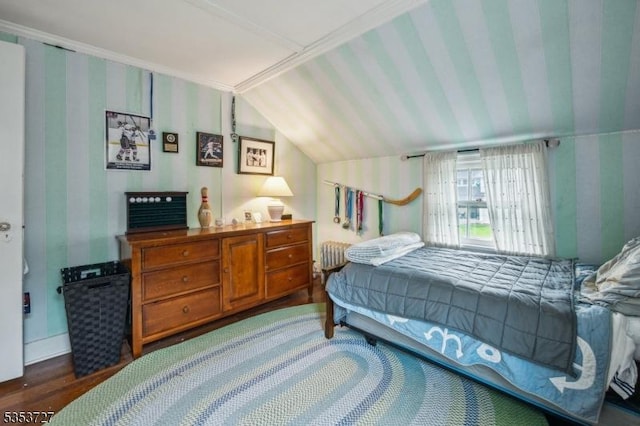 bedroom with lofted ceiling, radiator heating unit, wallpapered walls, and wood finished floors