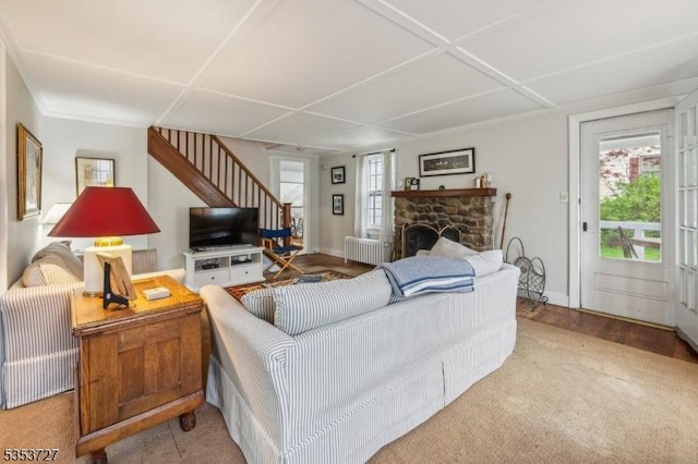living room with radiator heating unit, stairway, healthy amount of natural light, and baseboards