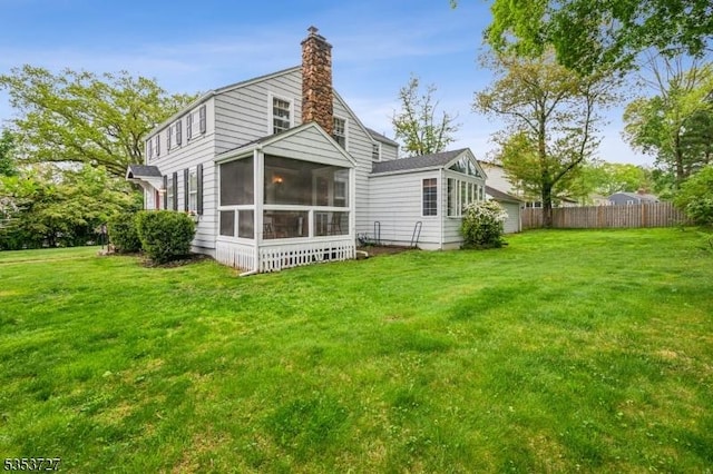 back of house with a sunroom and a chimney