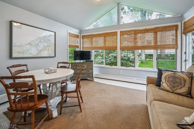 sunroom with lofted ceiling, a baseboard heating unit, and plenty of natural light