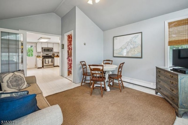 dining space featuring vaulted ceiling, baseboard heating, and baseboards