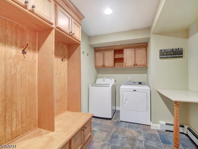 clothes washing area with cabinet space, washing machine and clothes dryer, stone finish flooring, baseboards, and a baseboard radiator