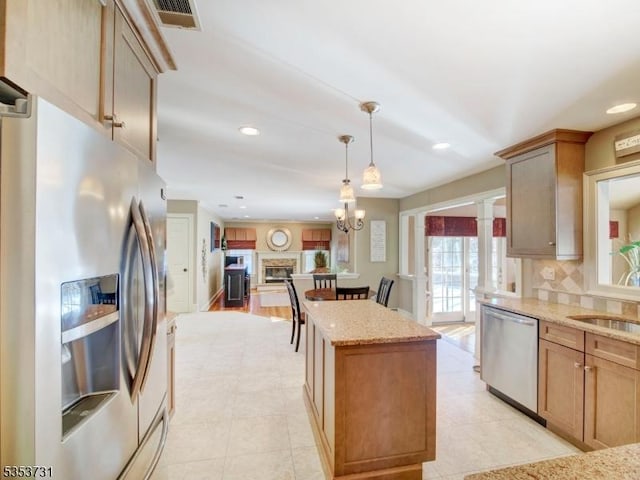 kitchen with appliances with stainless steel finishes, visible vents, recessed lighting, and a center island