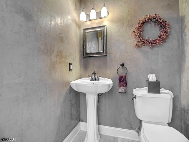 bathroom with toilet and baseboards