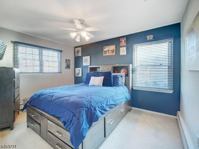 bedroom with a ceiling fan, baseboard heating, light colored carpet, and baseboards