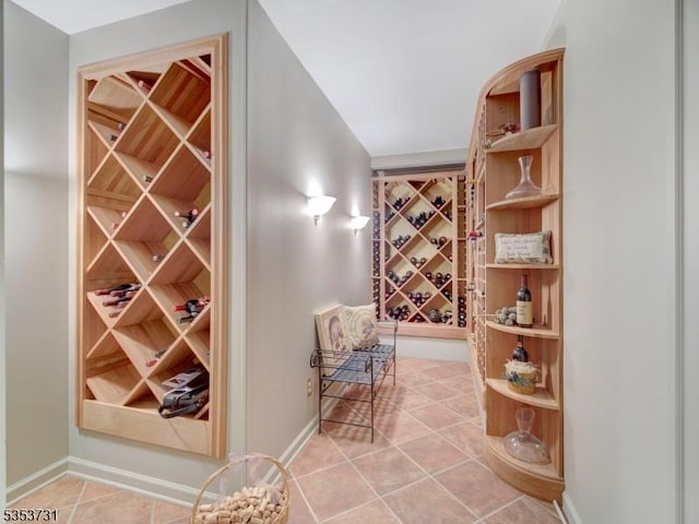wine area featuring light tile patterned floors and baseboards