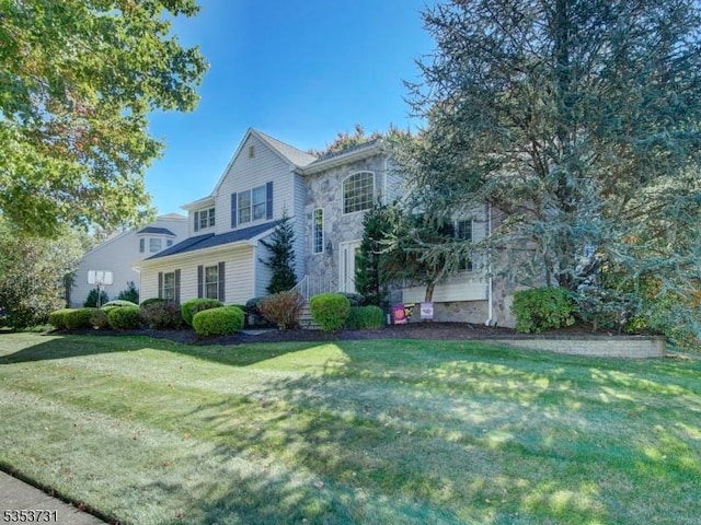 traditional-style home with a front lawn and stone siding