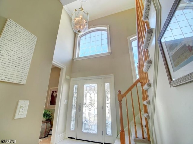 foyer featuring a towering ceiling, an inviting chandelier, and stairway